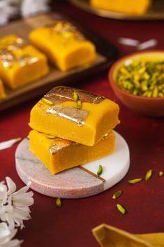 three pieces of yellow cake sitting on top of a white plate next to some flowers