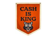 an orange banner with the words cash is king on it and a black cat's head