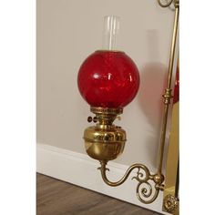 a red glass lamp sitting on top of a wooden floor