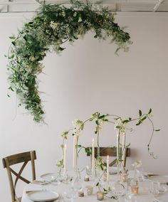 the table is set with candles and greenery