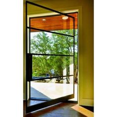 an open glass door with trees in the background