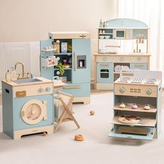 an assortment of toy kitchen furniture in a playroom with white walls and flooring