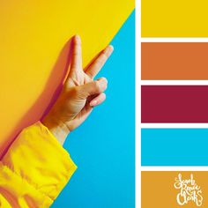 a person's hand making the peace sign on top of a yellow and blue background