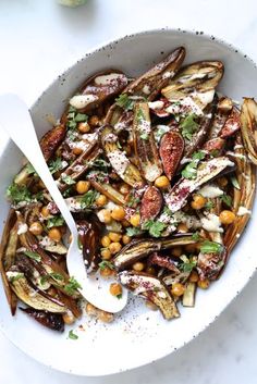 a white bowl filled with food and a spoon