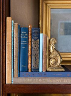 there is a bookshelf with many different books on it and a mirror in the background