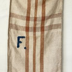 an old burlock with the letter f on it is hanging from a wall