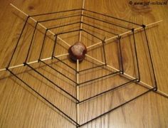 a wooden table topped with an upside down spider web and a ball on top of it