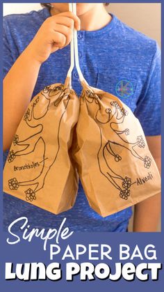 a young boy holding two brown paper bags with the words, simple paper bag lung project