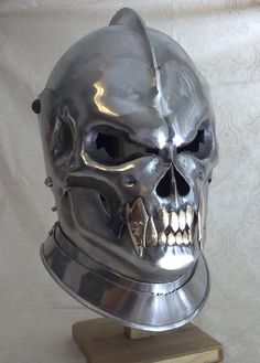 a metal skull wearing a helmet on top of a wooden block