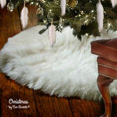 a christmas tree decorated with white feathers and lights is in the corner of a room