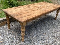 a wooden table sitting on top of gravel covered ground