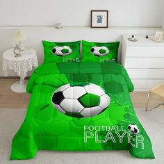 a bed with a green comforter and soccer ball on it