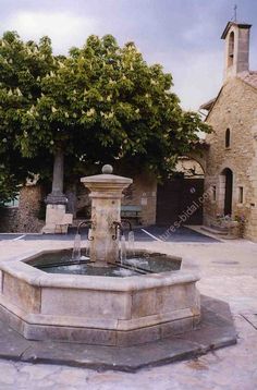 an old stone building with a fountain in the middle