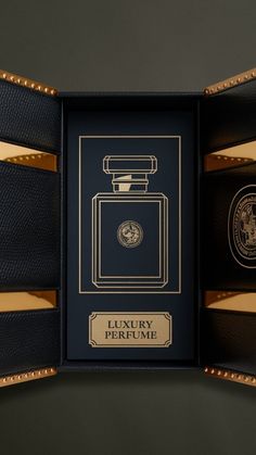 an open box with a black and gold label on the inside, containing a bottle of luxury perfume