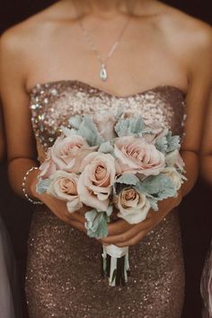 a woman holding a bouquet of flowers in her hands with sequins on it