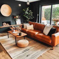 a living room filled with furniture and a fire place in front of a large window