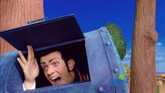 an animated image of a man peeking out of a blue suitcase with his hands in the air