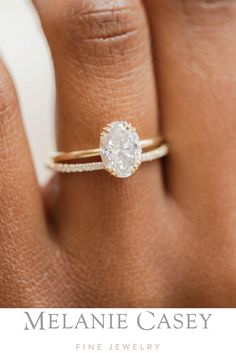 a woman's hand with a diamond ring on her finger and the words melanie casey fine jewelry