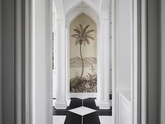 the hallway is decorated in black and white with a palm tree painting on the wall