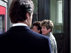 two women and a man standing in front of a door