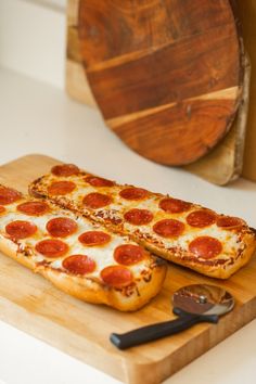 two slices of pepperoni pizza on a cutting board