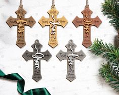 four wooden crosses with the names of different people on them hanging from a christmas tree