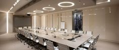 an empty conference room with white chairs and lights on the ceiling is pictured in this image