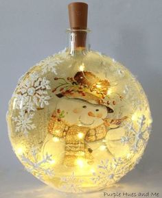 a lighted snowman ornament in a glass bottle