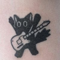 a black and white photo of a cat with a guitar tattoo on it's leg