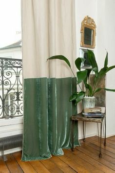 a living room with a large window and a plant on the floor next to it