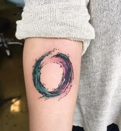 a woman's arm with a tattoo on it that has a circular design in the middle