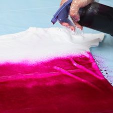 a person using a machine to dye a piece of fabric