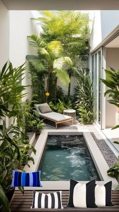 an indoor swimming pool surrounded by greenery