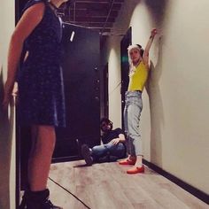 two girls are standing on roller skates and one is leaning up against the wall