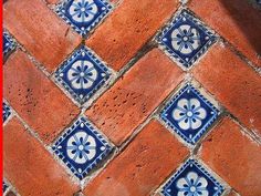 an orange and blue tiled floor with white flowers