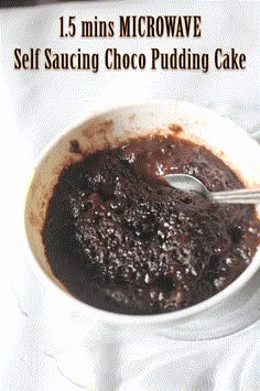 a white bowl filled with chocolate pudding on top of a table next to a spoon