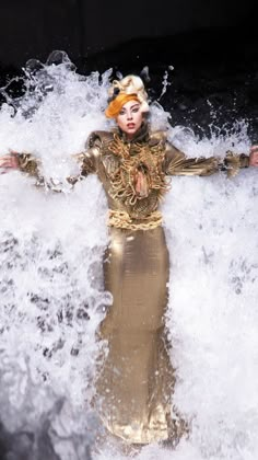 a woman standing in the water with her arms outstretched