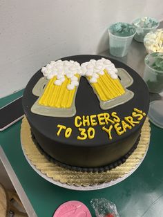 a birthday cake with beer mugs and cheers to 30 years written on the top