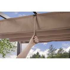 a person is holding onto the side of a awning