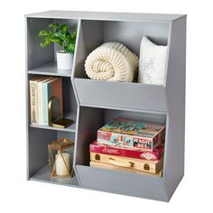 a book shelf filled with books next to a potted plant and other items on top of it