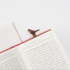 a bird figurine sitting on top of an open book