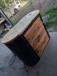 a large wooden barrel sitting on top of a cement ground