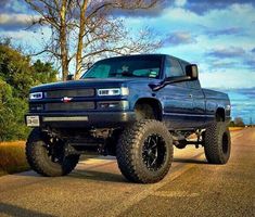 a large blue truck parked on the side of a road