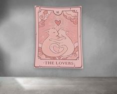 a pink playing card with two cats on it and the words the lovers written below