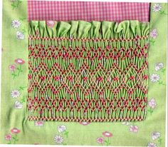 a close up of a piece of cloth with flowers on the bottom and green fabric