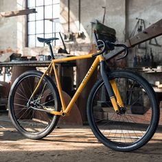 a yellow bicycle parked in an old workshop