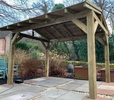 a wooden gazebo sitting in the middle of a garden