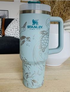 a blue travel mug sitting on top of a wooden table