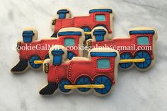 three decorated cookies in the shape of trains