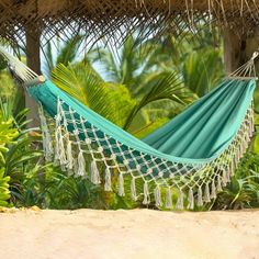 a blue hammock hanging from a straw hut